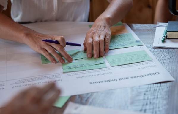 A woman organizing index cards on a table.