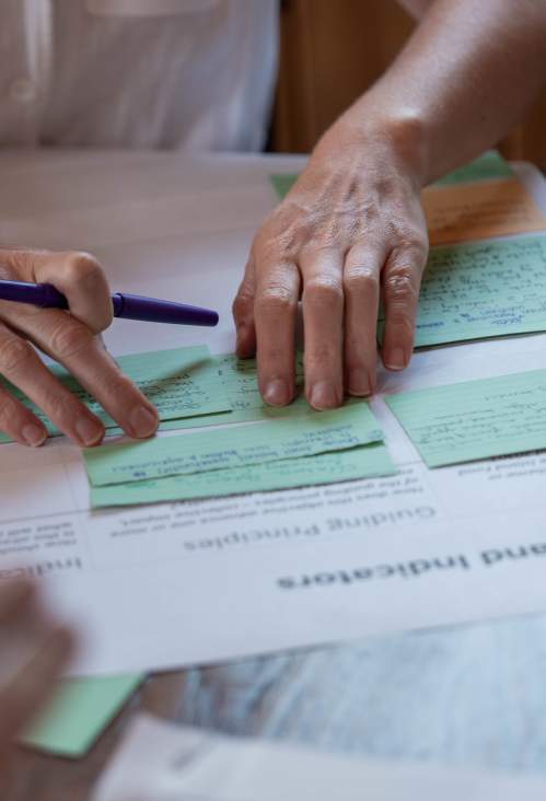 A woman organizing index cards on a table.