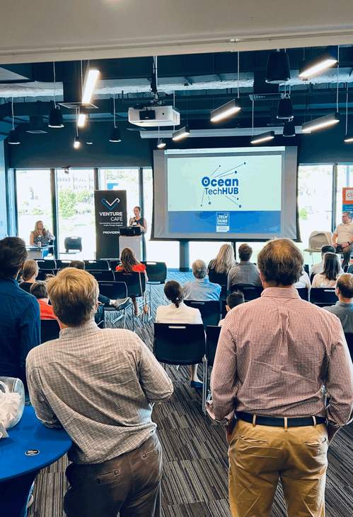 A room full of people looking at a presentation on a projector.